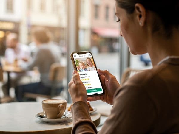 Parent browsing daycare websites on smartphone